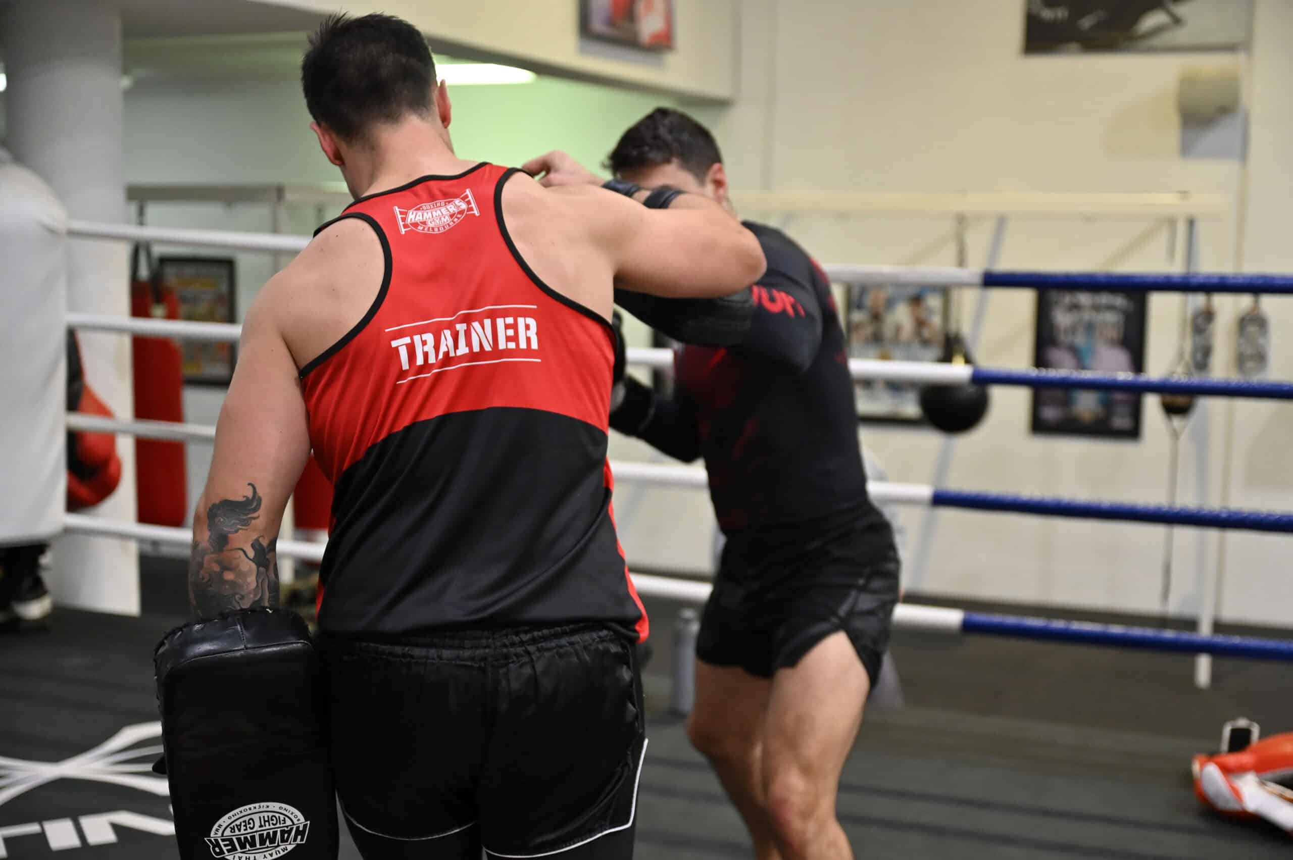Boxing coach working technique with a student in the ring at Hammer's Gym Nunawading