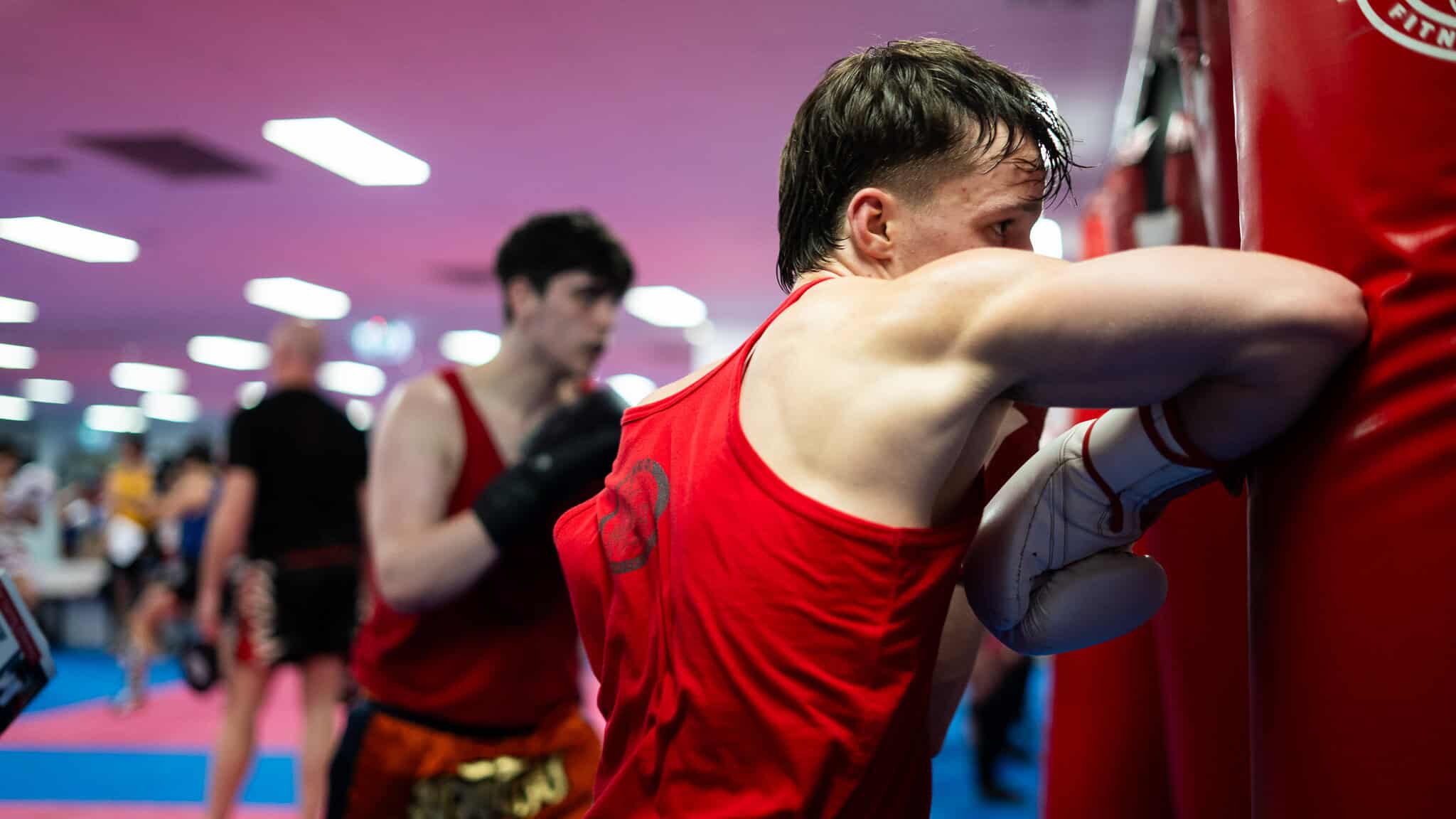 Teenage boxer working the heavy bag in a Muay Thai class at Hammer's Gym Nunawading